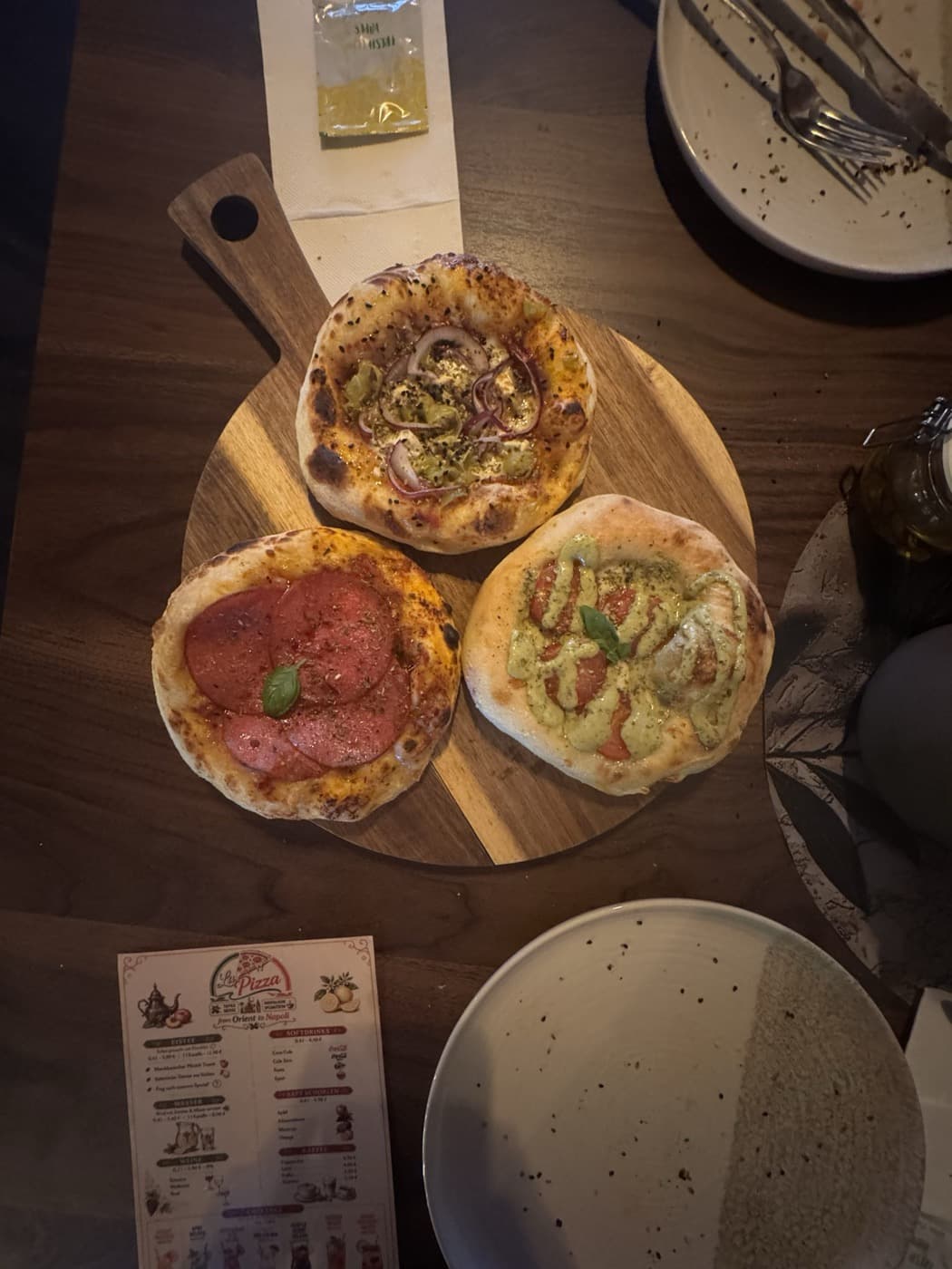 Drei Mini-Pizzen auf einem runden Holzbrett bei La Pizza Denkendorf