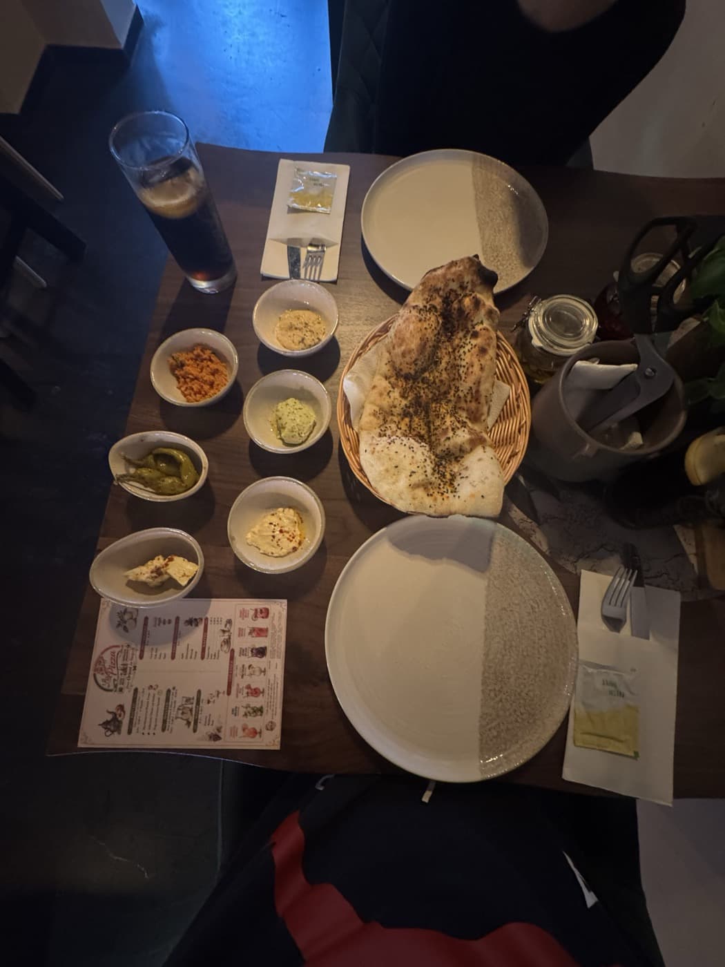 Orientalische Vorspeisen: Dips, eingelegte Peperoni und frisches Fladenbrot